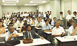 写真:会場いっぱいの報告集会
