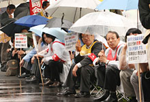 写真：雨の中、座り込み抗議