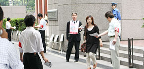写真：夕方本社前行動　会社帰りの従業員にビラを手渡す